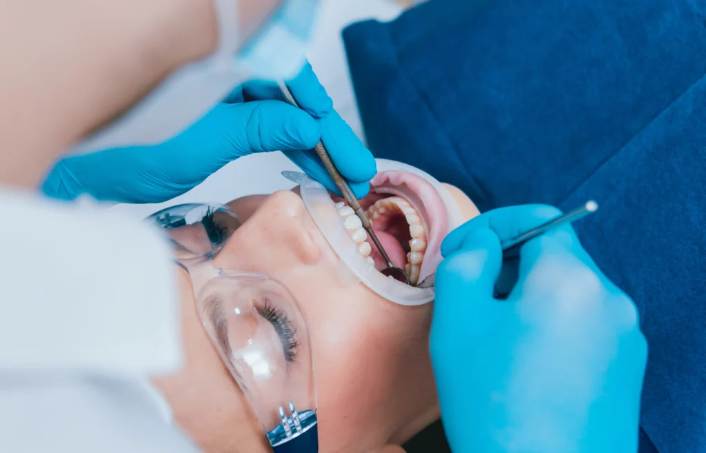Dentist examining patient's teeth with mirror and scaler | 24th Street Dental in Phoenix, AZ